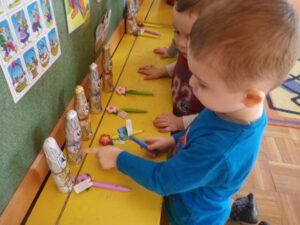 Zdjęcie przedstawiające dwóch przedszkolaków patrzących na zajączki wielkanocne