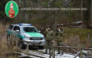 Zdjęcie dwóch strażników granicznych przy samochodzie